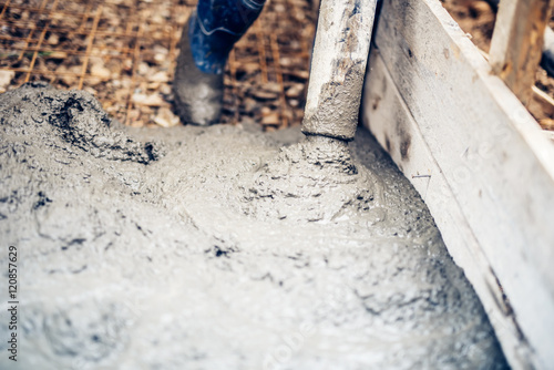 close up of cement pump tube on industrial construction site with worker handling