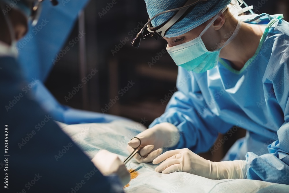 Surgeons performing operation in operation room Surgeons performing operation in operation room