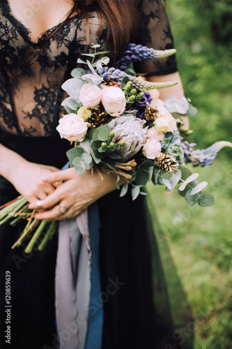 Bride in black dress with wedding bouquet in her hands 