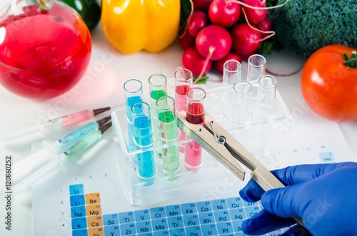 Foto Analyst in gloves takes test tube. Genetically modified food con