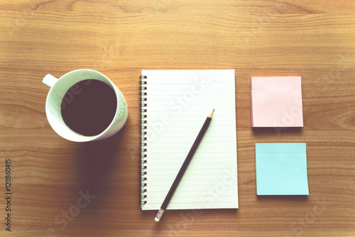 Travel Planning on Calendar and use post-it for note with a cup of coffee on a wooden table
