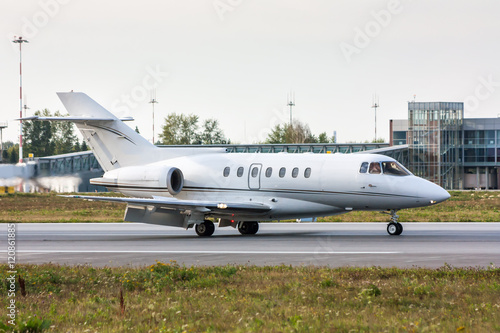 Business Jet on the runway in front of the airport terminal