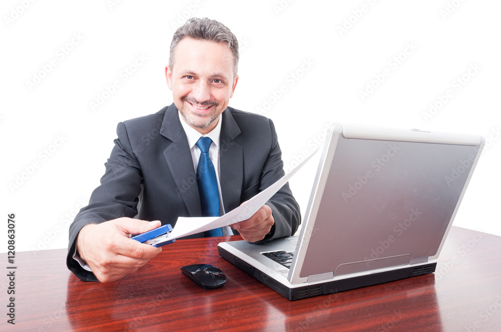 Man wearing suit at office holding stapler and documents Man wearing suit at office holding stapler and documents