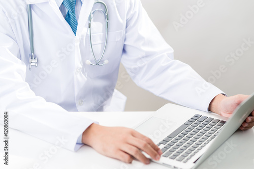 doctor typing on a laptop