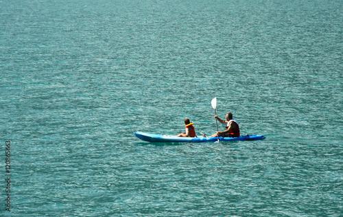 father and son at kayak in Molveno lake in Italy