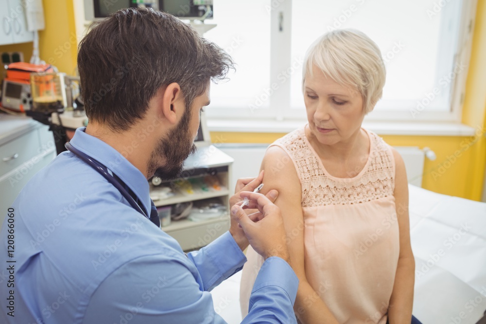 Male doctor giving an injection to a patient Male doctor giving an injection to a patient