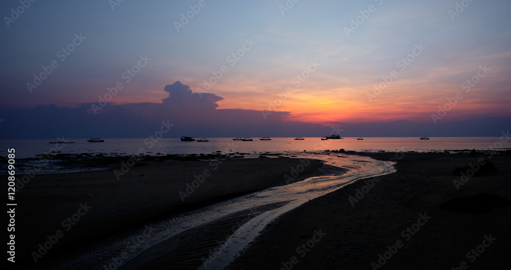Colorful sunset above the river flowing into the sea. Plenty of