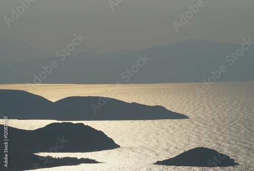 Sunset haze with flickering reflection between small islands in the sea