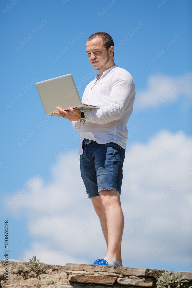 Happy business man looking to his laptop