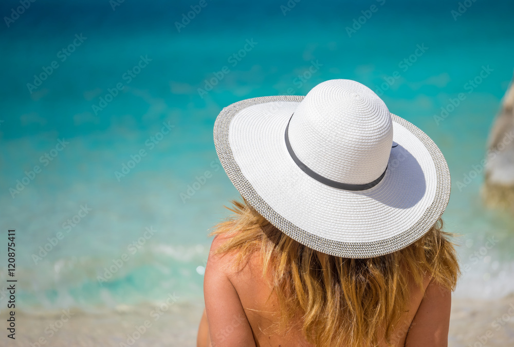 Young woman in white bikini looking at water