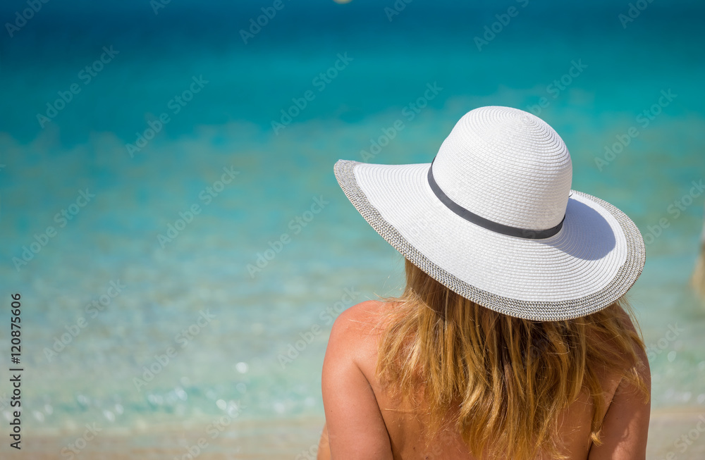 Young woman in white bikini looking at water