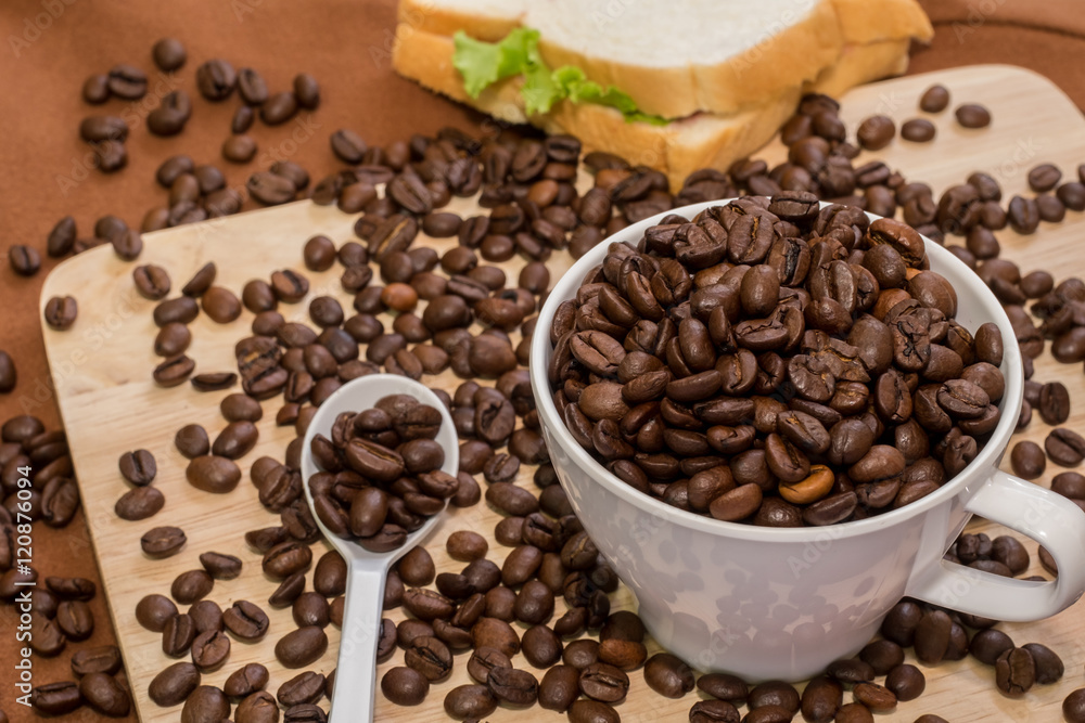 Coffee Cup with coffee beans on wood of coffee beans and sanback Coffee Cup with coffee beans on wood of coffee beans and sanback