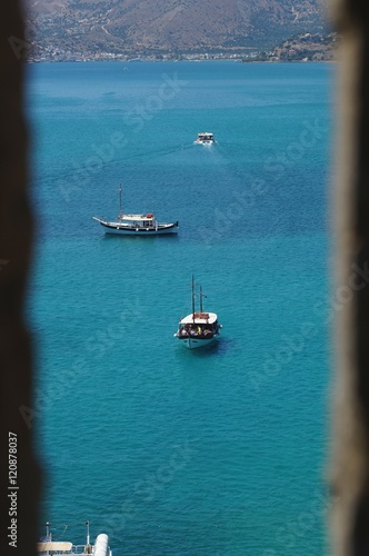 Photography Boats in Aegean sea seen through the embrasure of the Spinalonga fortress