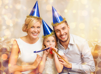 smiling family in blue hats blowing favor horns