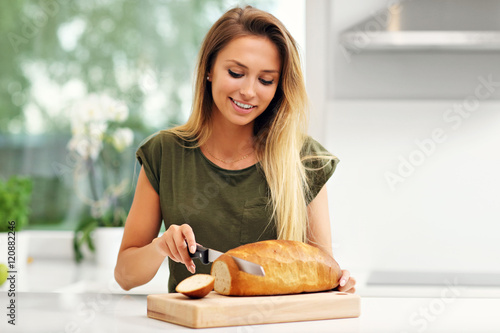 Φωτογραφία Woman slicing loaf of bread