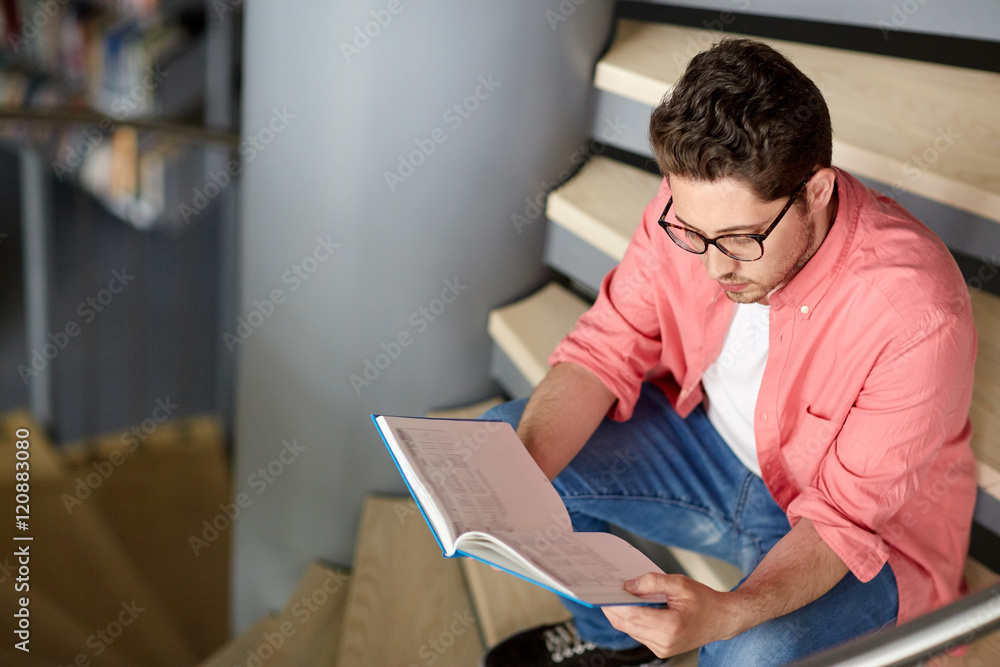 student boy or young man reading book at library student boy or young man reading book at library