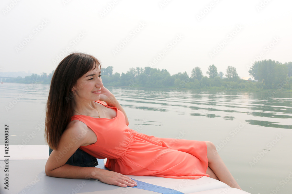 A woman lies on the stern of the yacht