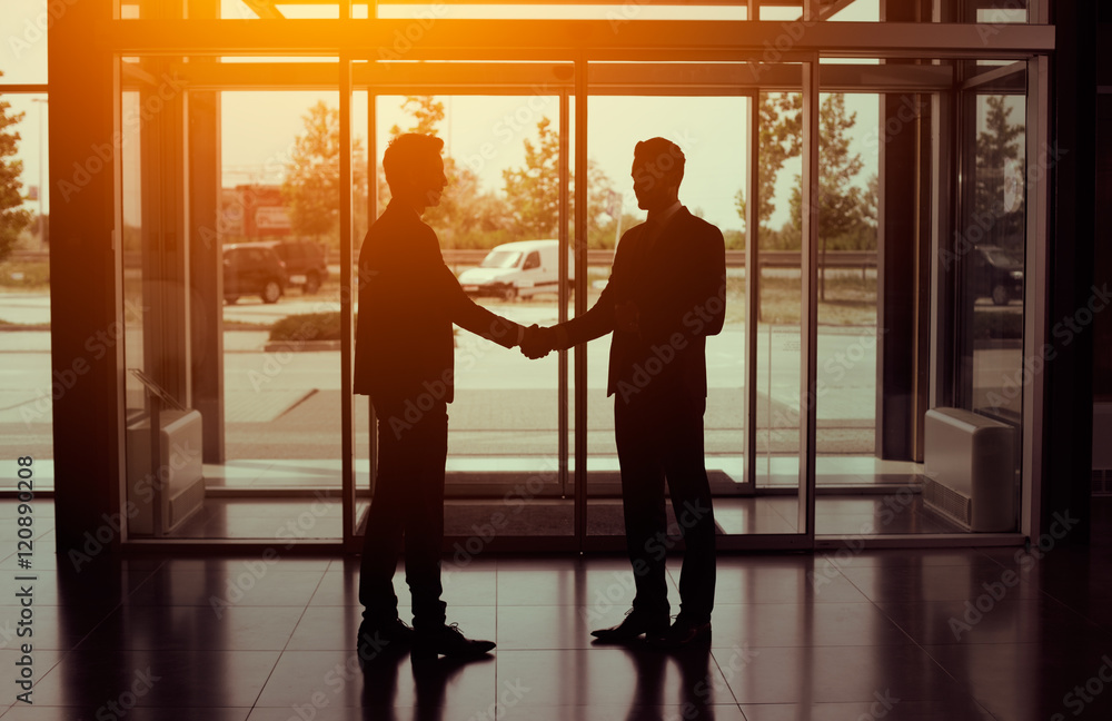 Silhouette of business partnership handshake Silhouette of business partnership handshake