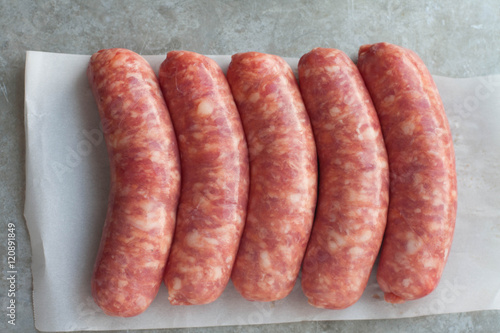 Raw sausages on wax papered gray background 