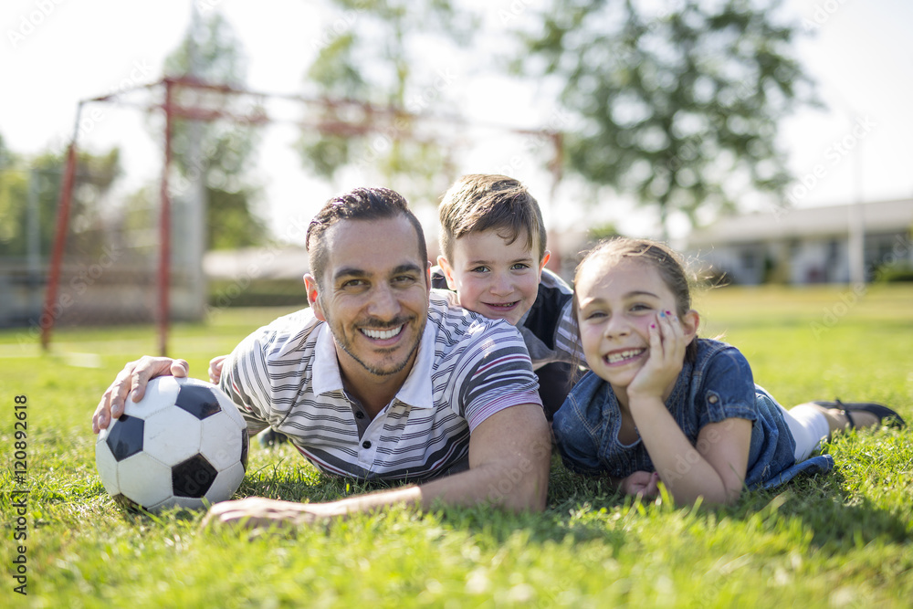 man with child playing football on field man with child playing football on field