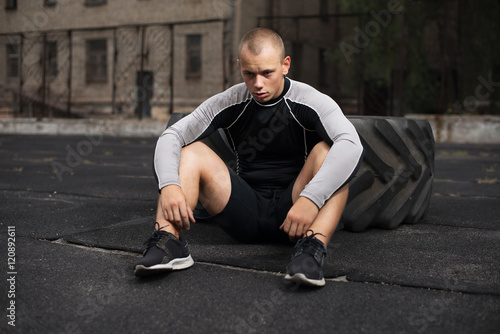 athlete sits at the tire, fatigue CrossFit