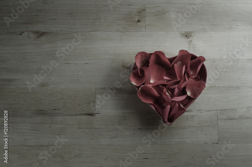 Overhead of Rose Petals Filling Heart Shaped Bowl photo