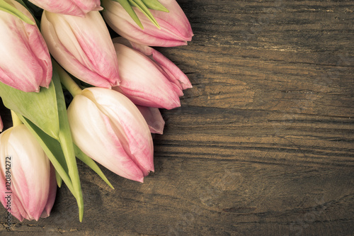 Fototapeta Naklejka Na Ścianę i Meble -  Vintage faded pink tulips. Flowers isolated on wood background with space for text.