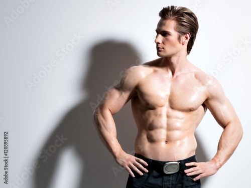 Handsome muscular young man posing at studio.