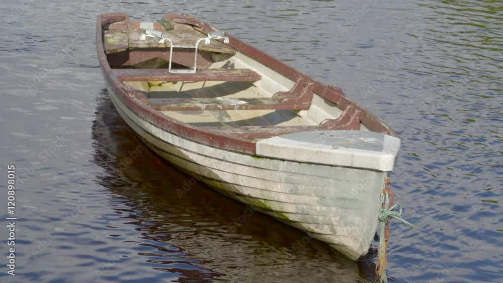 An old abandoned floating boat it is blue in color with brown sides An old abandoned floating boat it is blue in color with brown sides