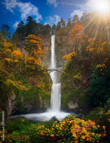 Multnomah Falls in Autumn foliage colors with shining sun