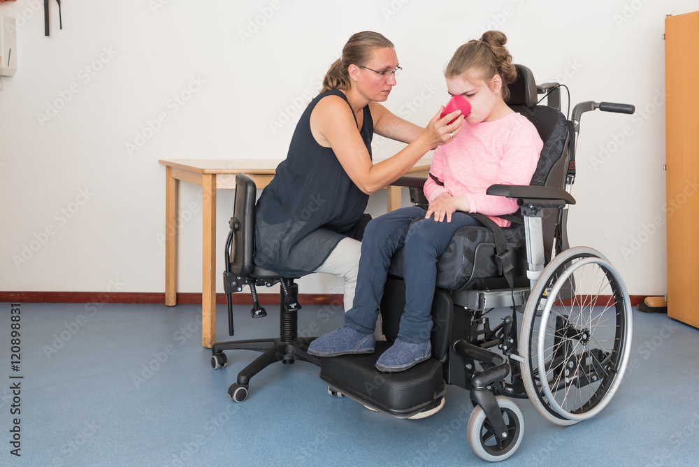 Working together with disability / Disability a disabled child in a wheelchair being cared for by a voluntary care worker Working together with disability / Disability a disabled child in a wheelchair being cared for by a voluntary care worker