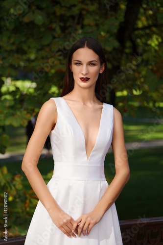 Beautiful girl in long white dress with a deep neckline. Fashion © boomeart