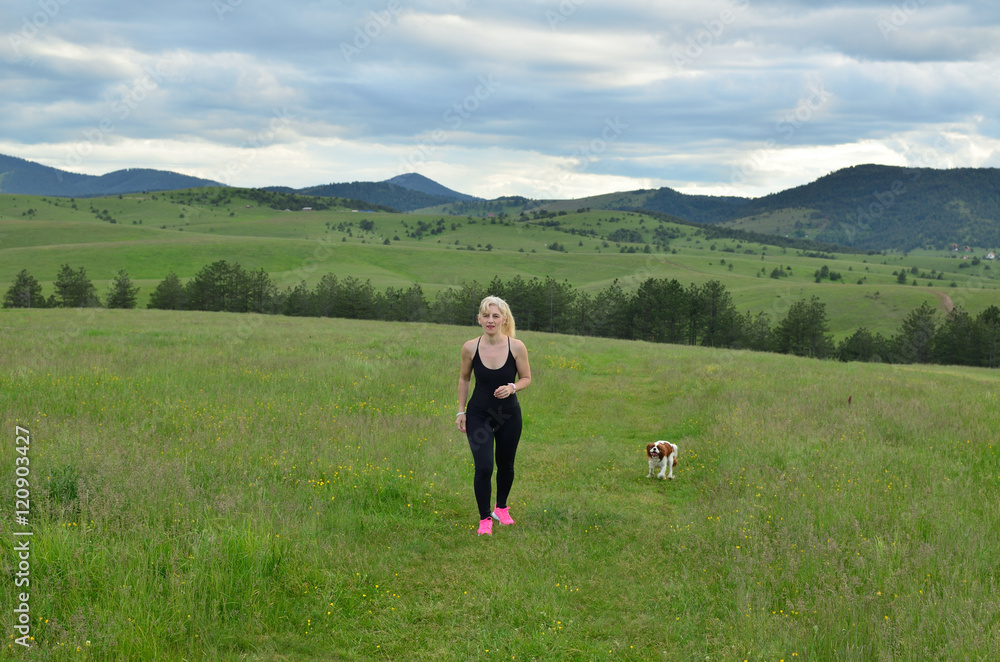 Fototapeta premium Woman hiking with her dog in mountain landscape in spring