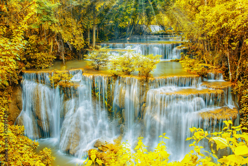 Beautiful  waterfall in autumn forest with ray light.