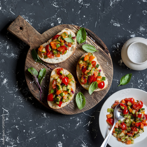 Sandwiches with quick ratatouille on rustic cutting board on a dark background. Delicious healthy vegetarian food. Top view photo