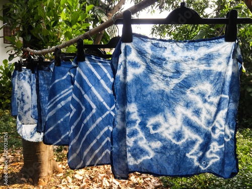 Papier peint Beautiful natural indigo tie dye fabric with garden view in background