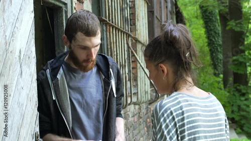 Man buying drugs from the dealer and giving money next to the abandoned building

