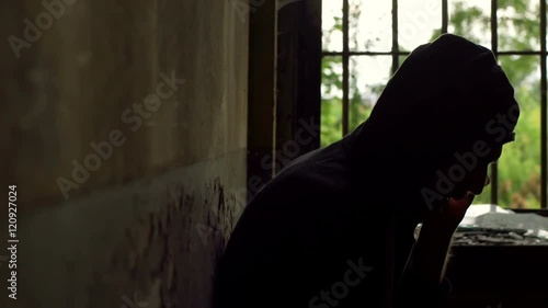 Man sitting next to the bars and having a call on cellphone, steadycam shot
