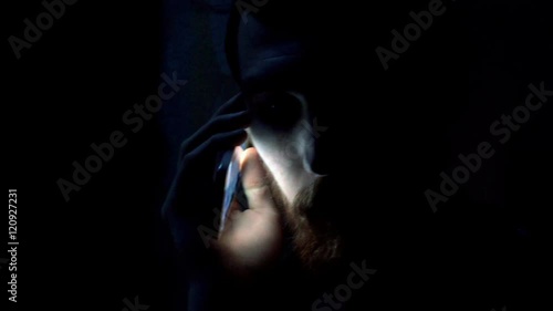 Man having a call on cellphone while standing in the darkness, steadycam shot
