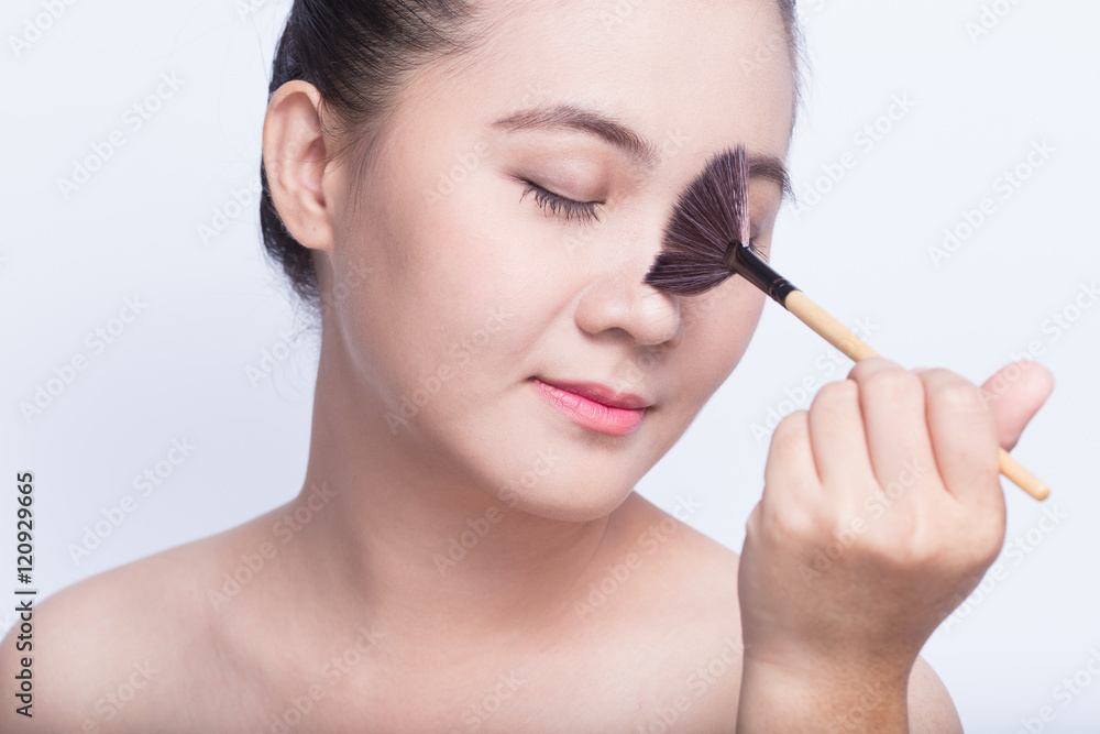 Beauty shot of woman holding the makeup brush Beauty shot of woman holding the makeup brush