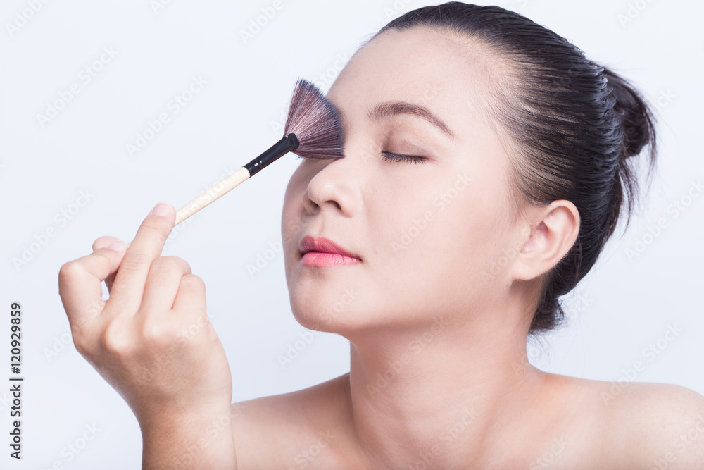 Beauty shot of woman holding the makeup brush Beauty shot of woman holding the makeup brush