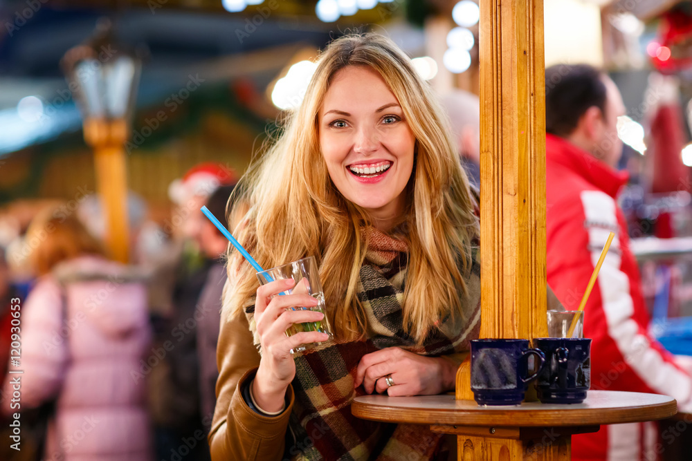 woman drinking hot punch on German Christmas market.
