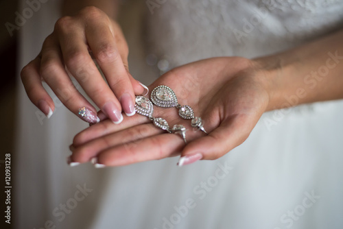 Wedding earrings on a female hand, she takes the earrings, the b