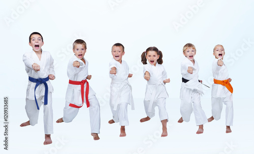 On a light background six karateka beating punch arm