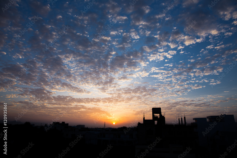 beautiful sunrise with colorful sky and clouds taken from a terrace with silhouette of buildings