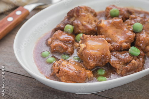 Braised pork ribs with green peas in bowl