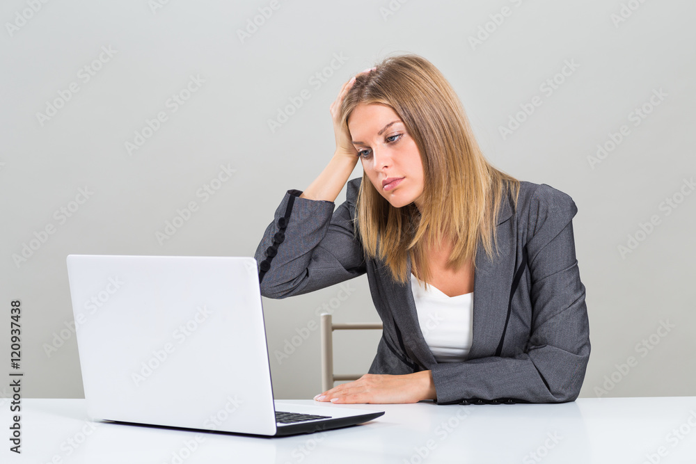 Portrait of very despair businesswoman looking at her laptop and sitting at the table.
Portrait of very despair businesswoman looking at her laptop and sitting at the table.
