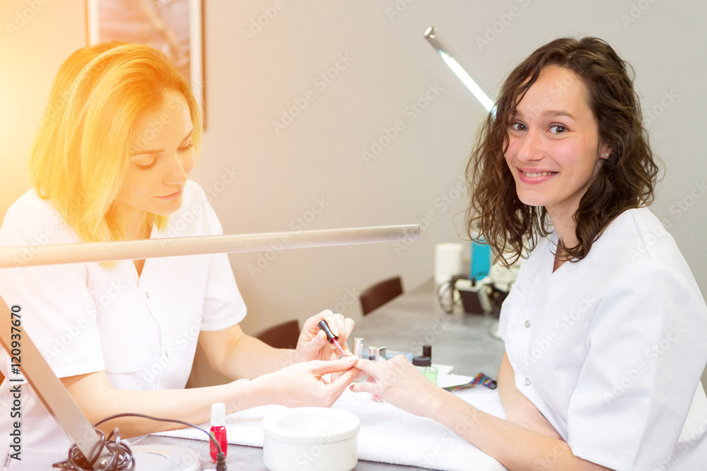 Young attractive beautician students practising during courses Young attractive beautician students practising during courses