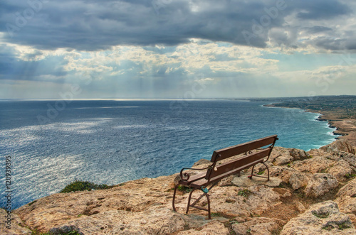 bench on edge of cliff overlooking sea