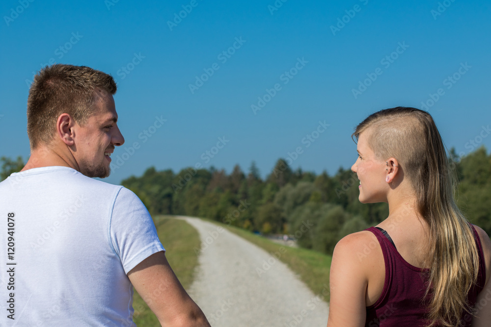 Obraz premium Junges Paar schaut sich beim Spaziergang verliebt an